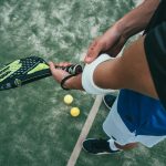 Person Holding Black and Green Tennis Racket
