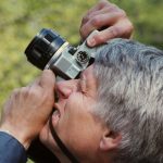 man in blue long sleeve shirt holding black and silver dslr camera
