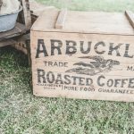 brown wooden storage box beside barrel on grass field