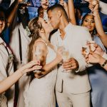 man in white suit holding woman in white dress